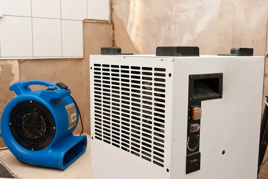 An air mover and a dehumidifier drying a room with the lower drywall removed in a Spring Hill, TN home