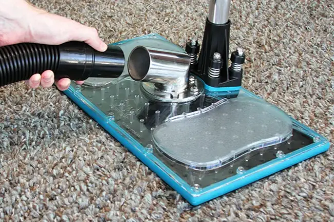 Extraction tool pulling water out of wet carpet during a dry-out