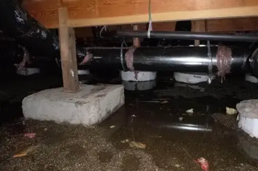Water pooled under the floor joists in a crawl space