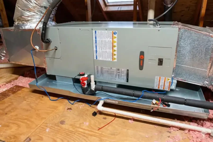 Attic air handler sitting in a drain pan with its condensate line, AC condensate leak water damage in Spring Hill, TN