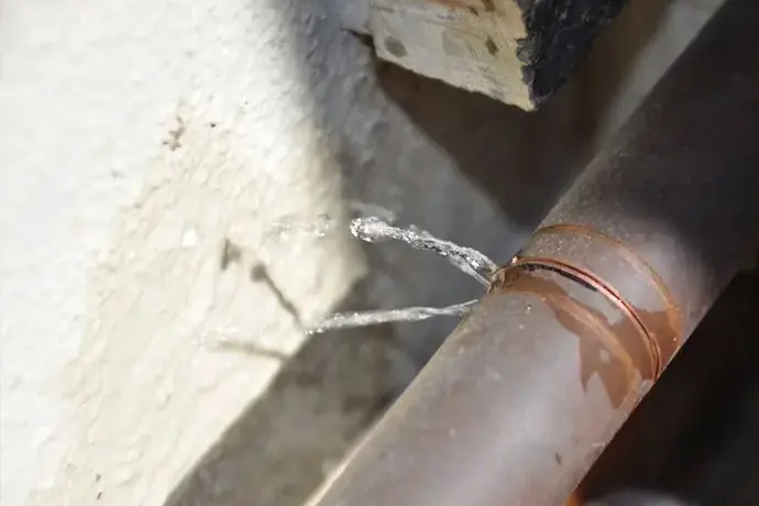 Water spraying from a leaking copper pipe, burst pipe water damage in Spring Hill, TN