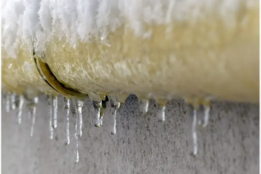 Icicles hanging from a split pipe after a hard freeze, frozen pipe water damage in Spring Hill, TN