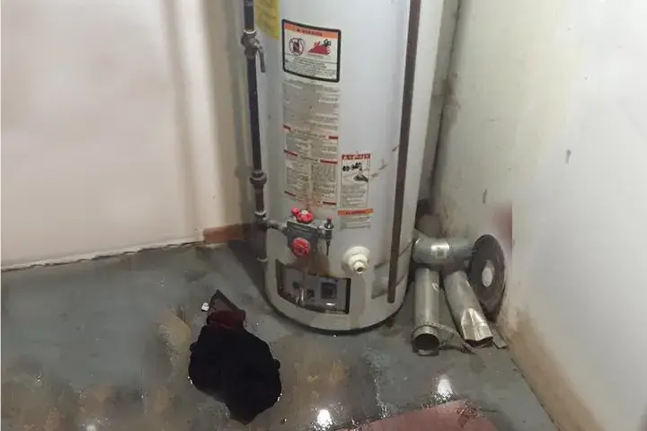 Water pooled on the floor around the base of a gas water heater, water heater leak cleanup in Spring Hill, TN